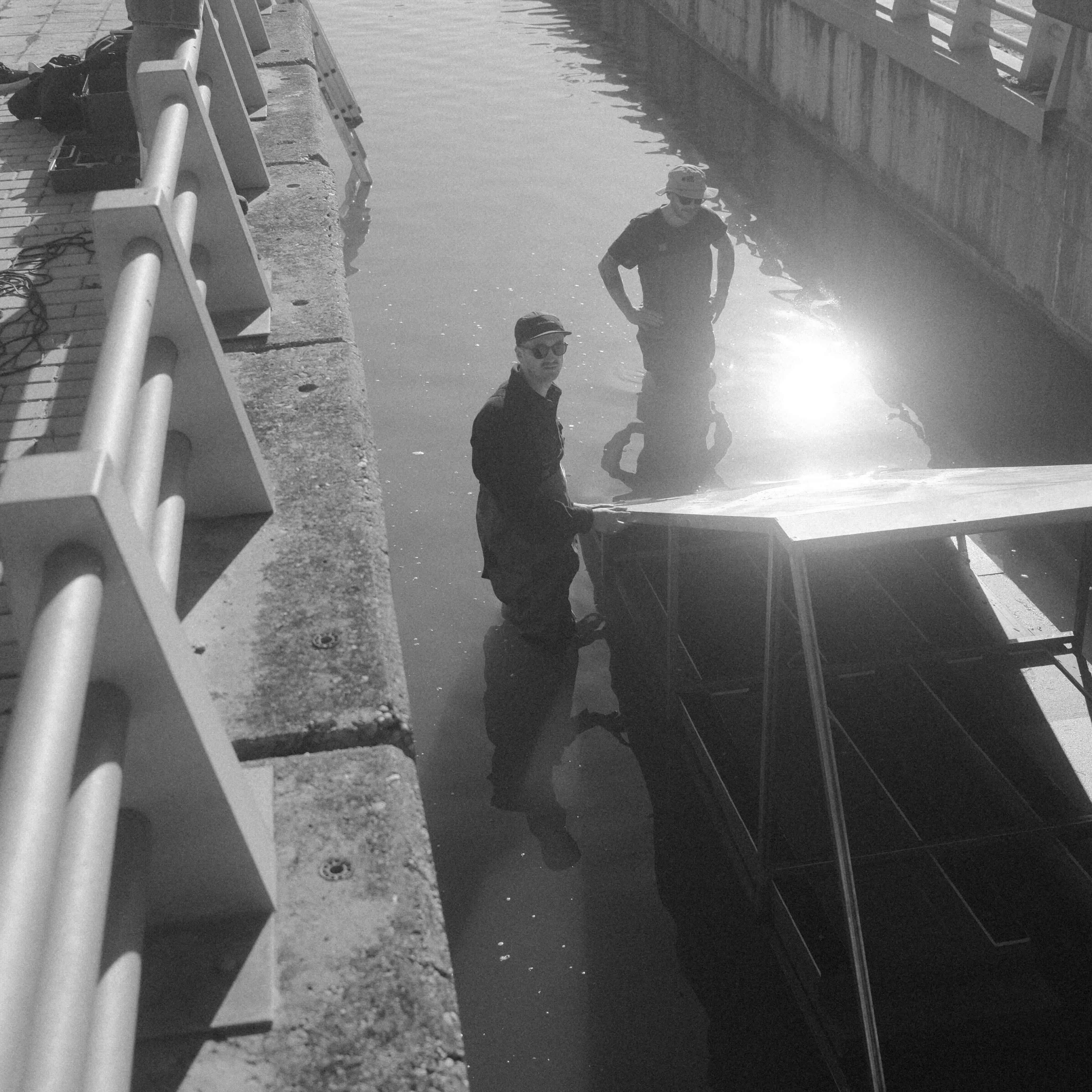 Crew setting up rigging near water